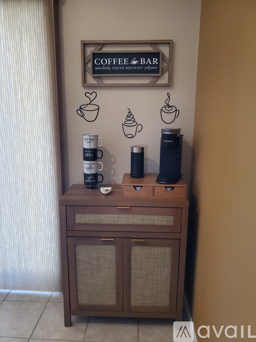 A wooden cabinet with coffee cups and a sign that says "Coffee Bar".