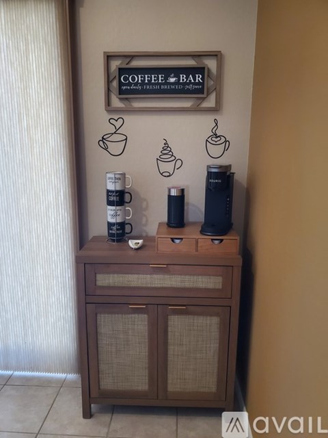 A wooden cabinet with coffee cups and a sign that says "Coffee Bar".