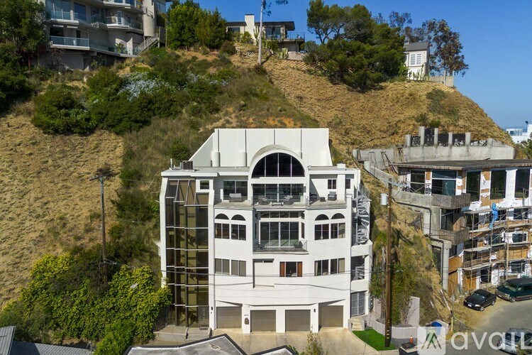 A house with a hill in the background and a city in the distance.