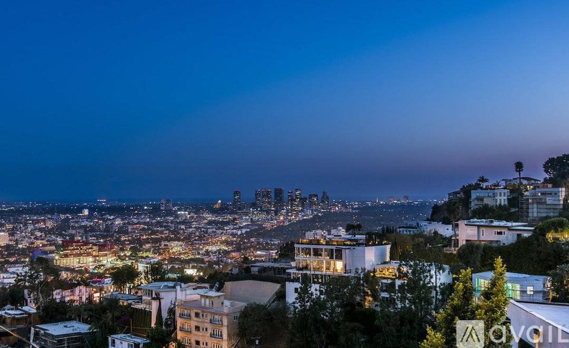 A cityscape at night with buildings illuminated against a dark sky.