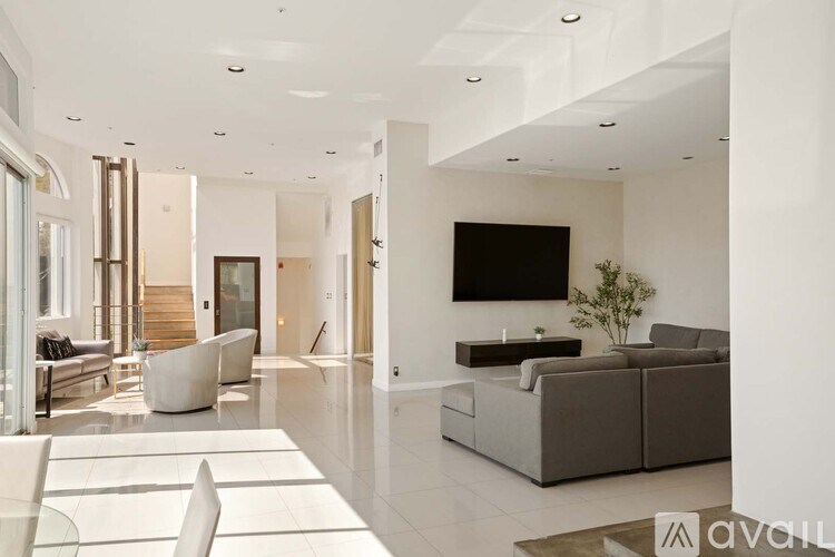 A spacious living room with a fireplace and a painting on the wall.