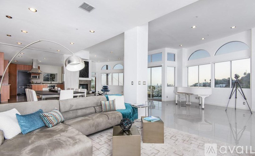 A modern living room with a grey sofa and a white coffee table.