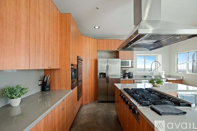A living room with a couch, a table, and a painting of a man's face on the wall.