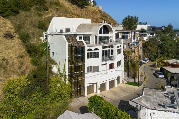 A modern two-story house with a balcony on the second floor.