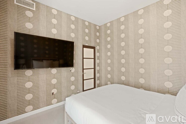 A bedroom with a large bed, a chair, and a fireplace.