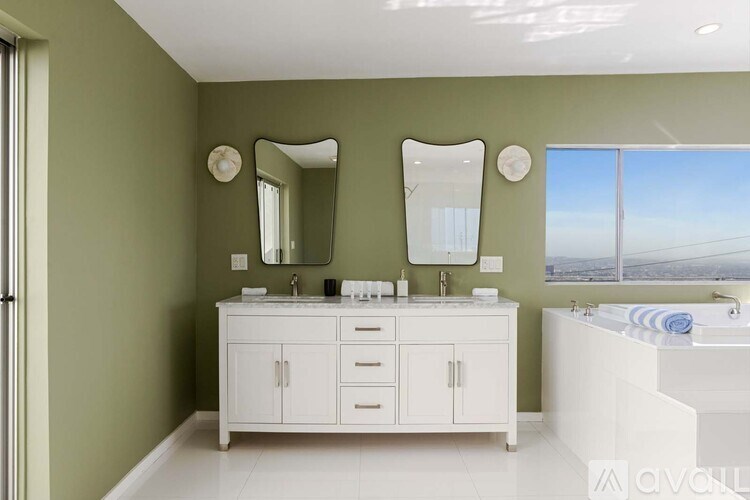 A dining room with a table and chairs and a wall of paintings of women's faces.