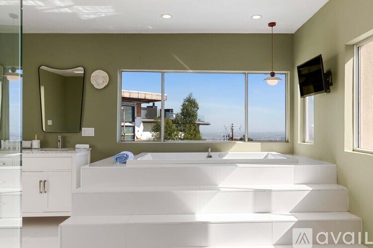 A bedroom with a bed, nightstand, and artwork on the wall.