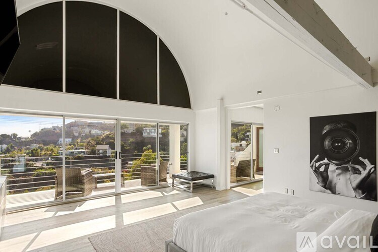 A modern outdoor seating area with a glass table and chairs.