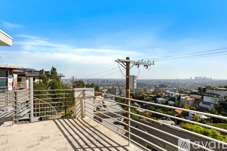 A balcony with a metal railing overlooks a cityscape.