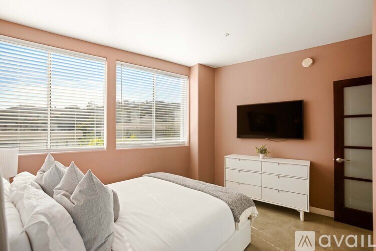 A bedroom with a bed, dresser, and television.