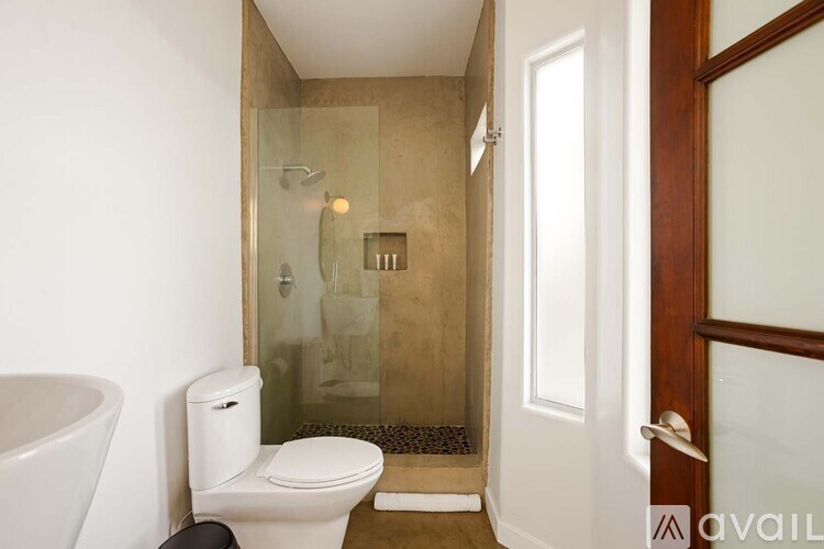 A bathroom with a toilet, a bathtub and a glass shower stall.