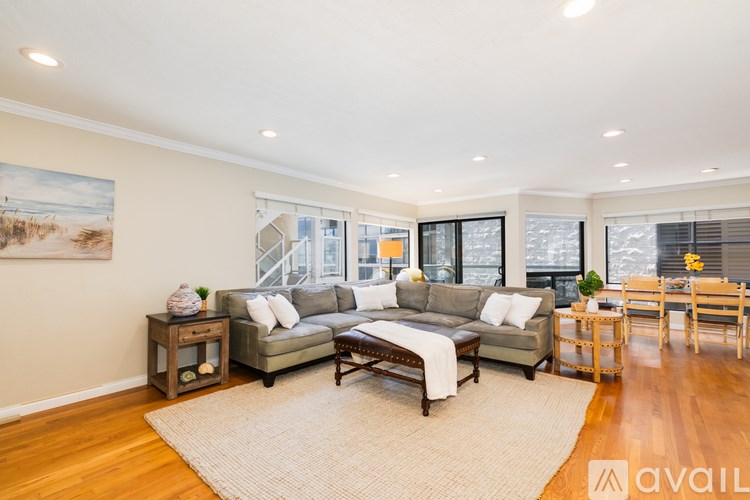 A living room with a large couch and a painting on the wall.