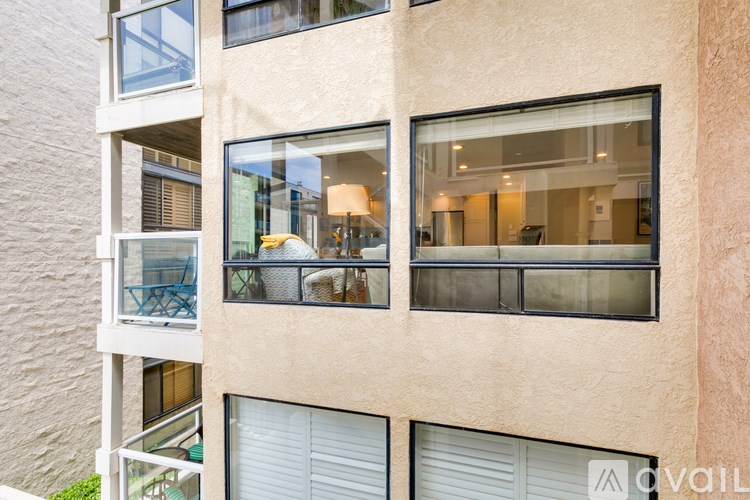 A building with a balcony and a window with a view of the balcony.