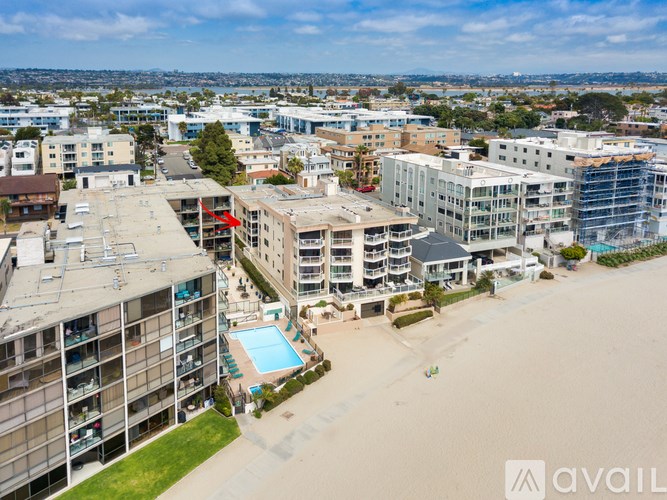 A bird's eye view of a beachfront apartment complex with a pool.