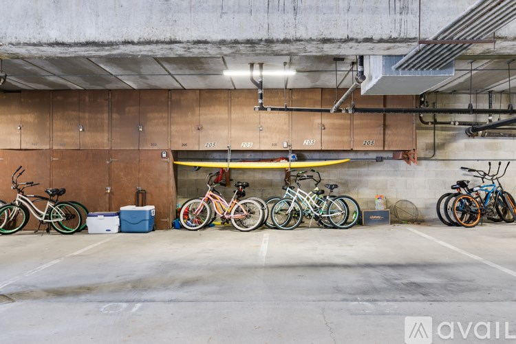 A row of bicycles are parked in a garage.