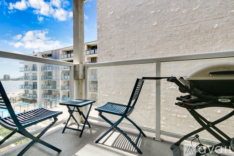 A balcony with a table and chairs overlooking a building.