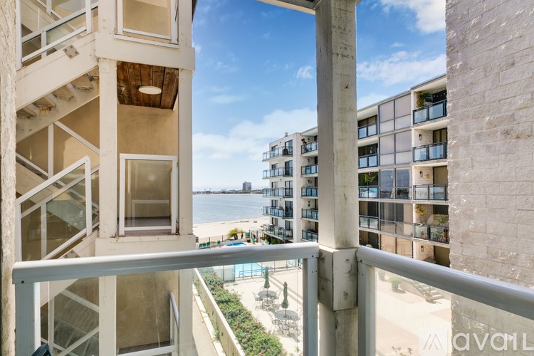 A balcony with a view of the beach and buildings.