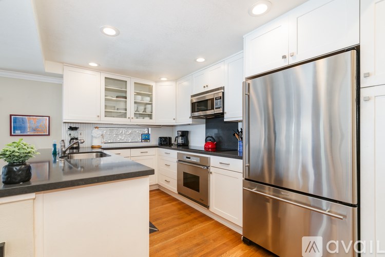 A modern kitchen with a large refrigerator and stainless steel appliances.