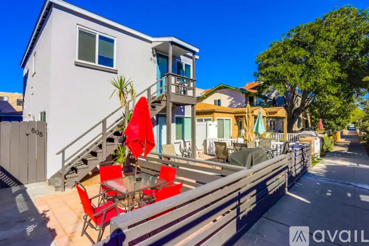 A modern house with a balcony and a glass table with chairs.