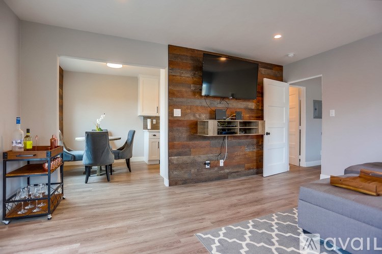 A modern living room with a wooden accent wall and a bar area.