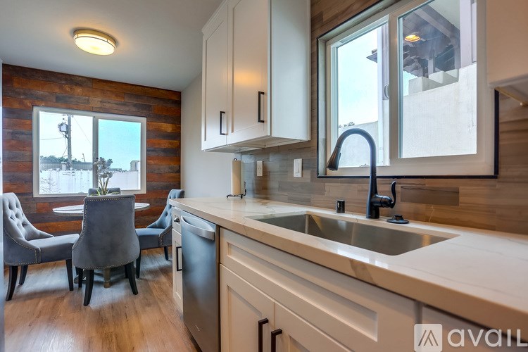 A kitchen with a wooden wall and a window.