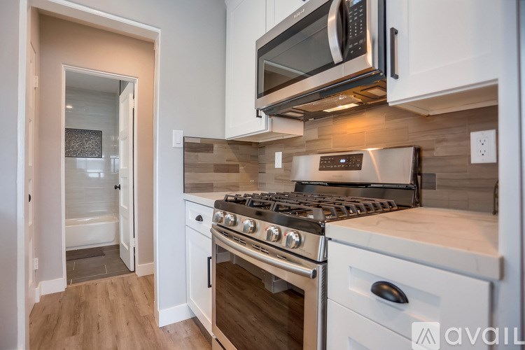 A modern kitchen with a stainless steel oven and microwave above it.