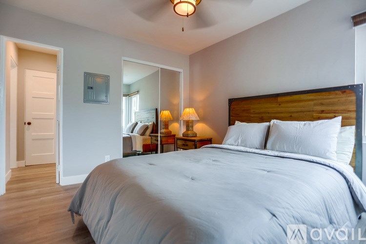 A bedroom with a large bed and a wooden headboard.