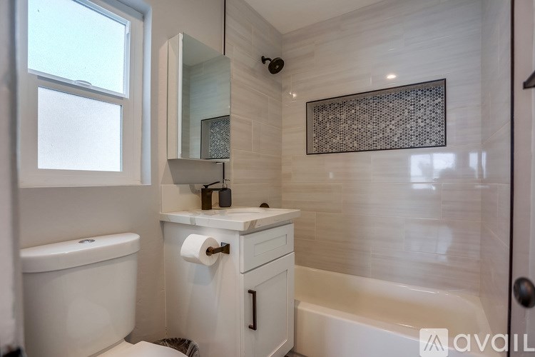 A bathroom with a white tub, toilet, and sink.