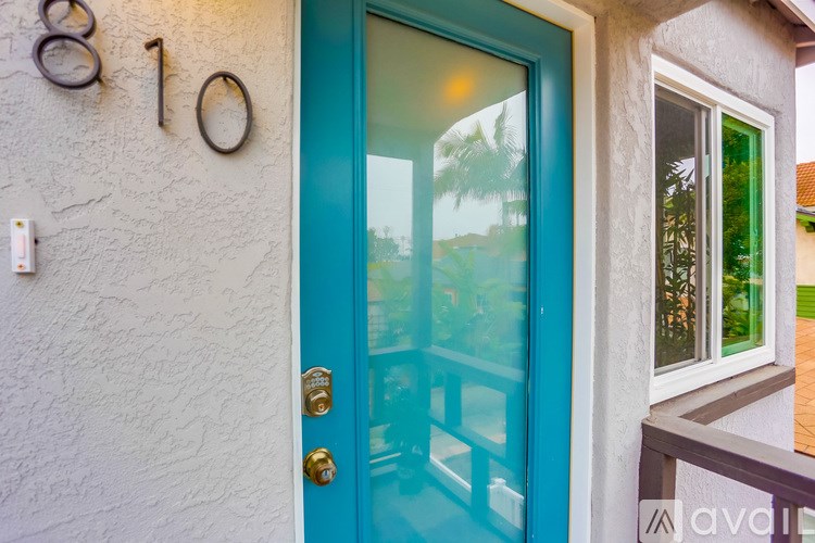 A blue door with a glass window and a number 10 on the wall above it.