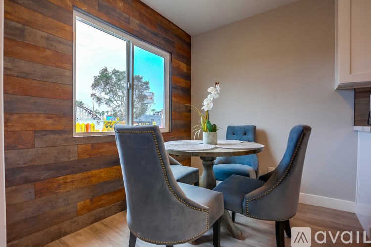 A dining room with a wooden wall and a table with chairs.