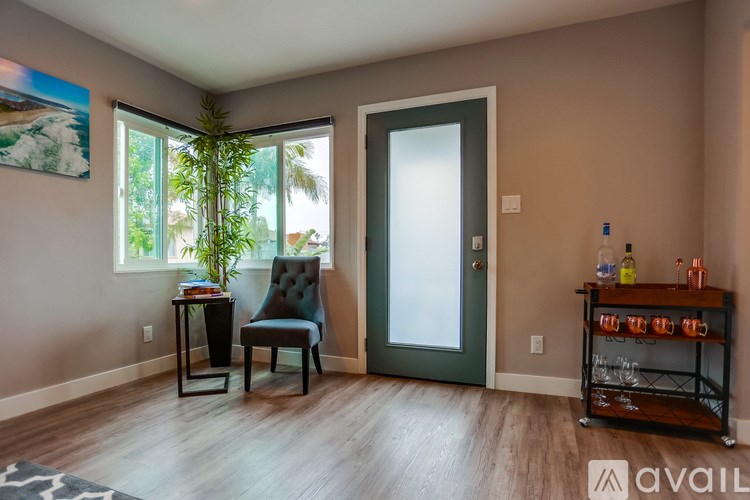 A room with a chair, a table, and a plant.