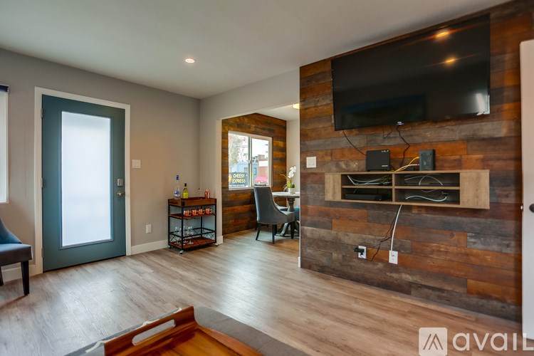 A living room with a wooden wall and a flat screen TV mounted on it.