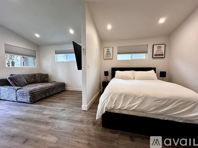 A bedroom with a large bed and a couch.