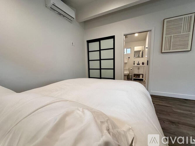 A bedroom with a large bed and a mirror on the wall.