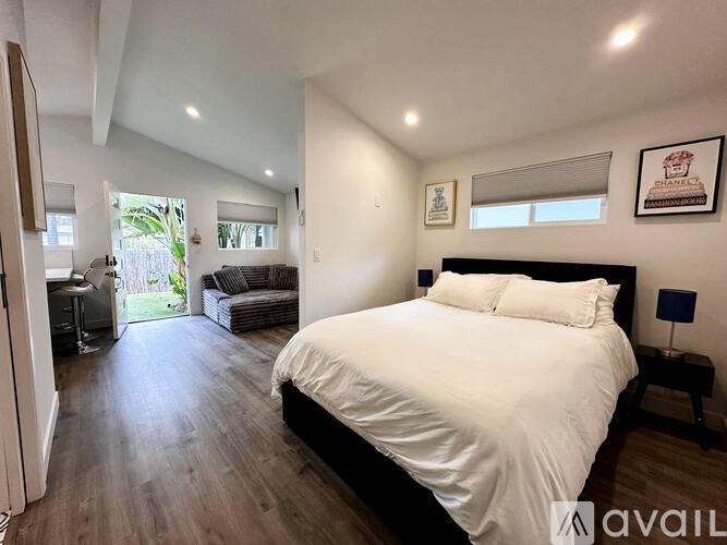 A bedroom with a large bed and a balcony.