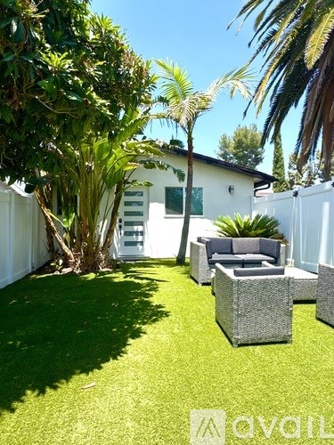 A backyard with a white fence and a patio set.
