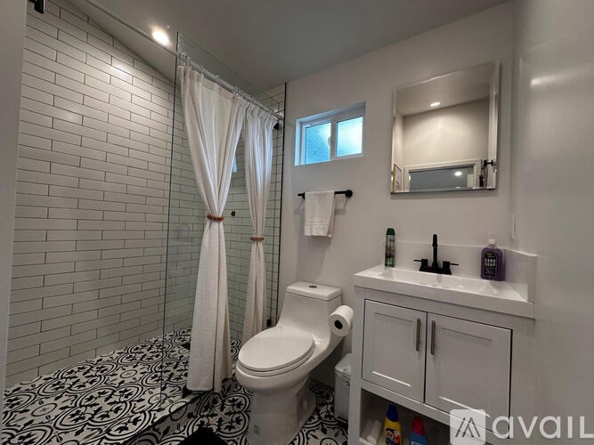 A bathroom with a toilet, sink, and shower.