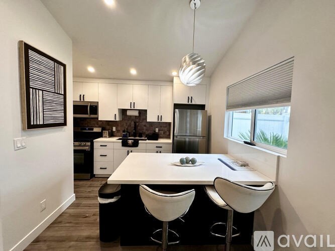 A modern kitchen with a dining table and chairs.