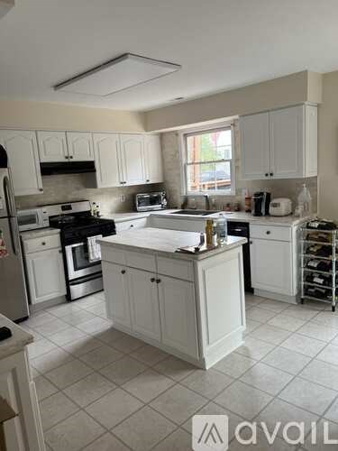 A kitchen with white cabinets and appliances.