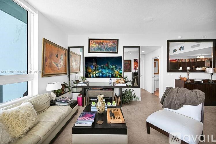 A living room with a white couch, a coffee table, and a painting on the wall.