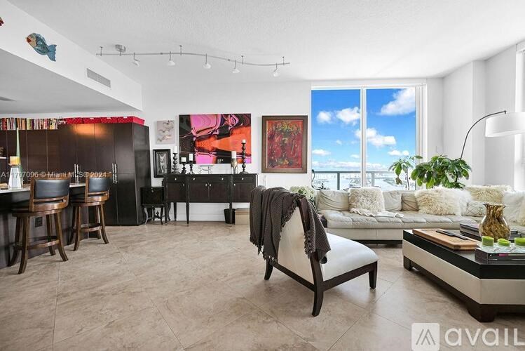 A living room with a large window and a view of the ocean.