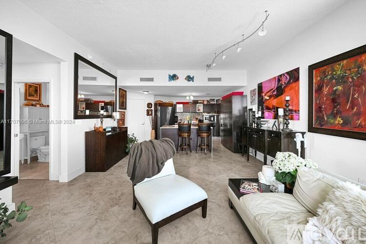 A living room with a white couch and a grey chair.