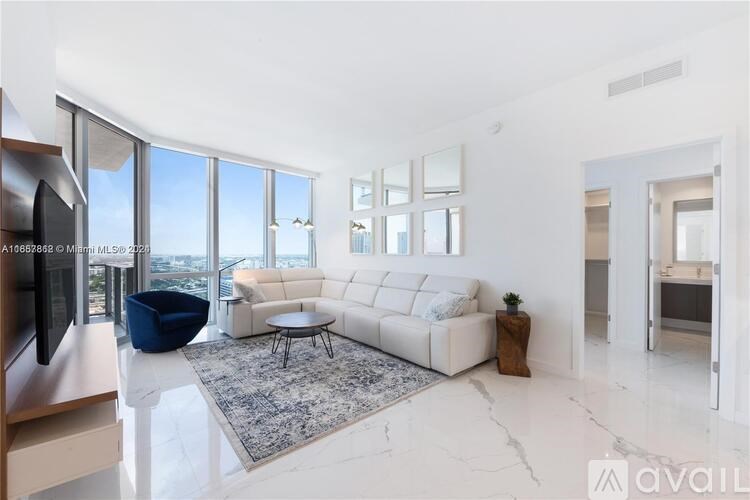A living room with a white sofa, a blue chair, and a coffee table.