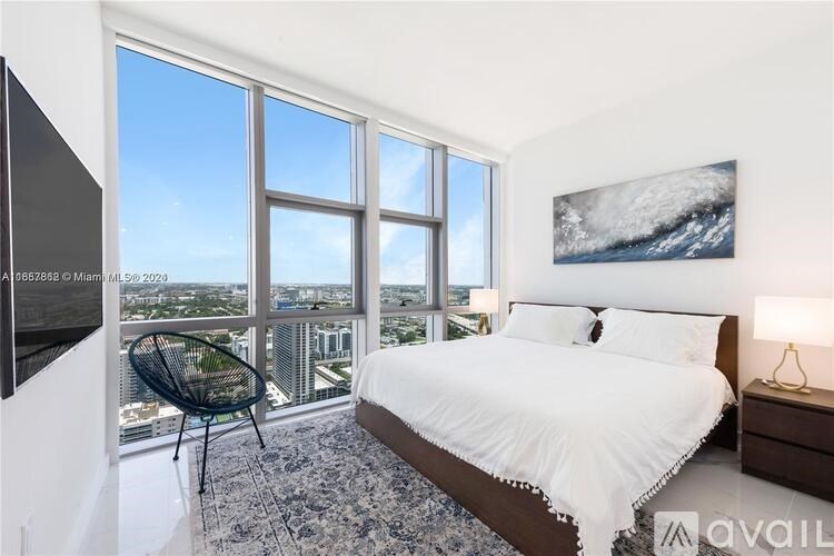 A bedroom with a large bed and a view of the city.