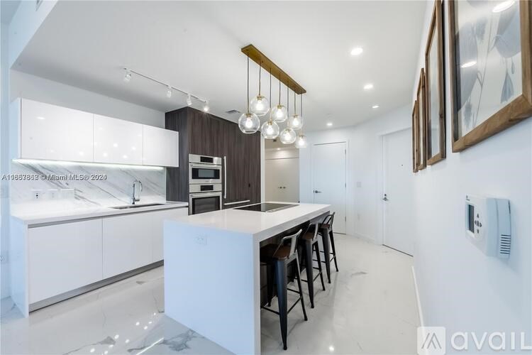 A modern kitchen with white cabinets and a central island.