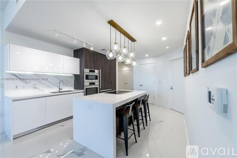 A modern kitchen with white cabinets and a central island.