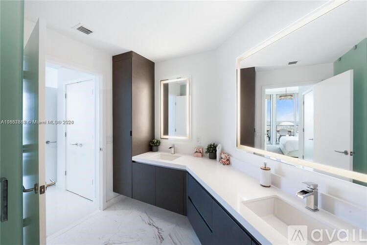 A bathroom with a white countertop and a large mirror.