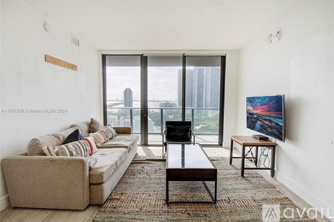 A living room with a couch, a coffee table, and a television.