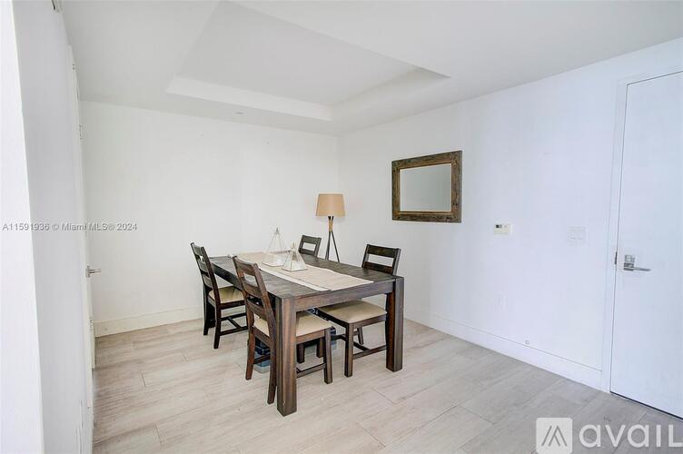 A dining room with a wooden table and chairs.