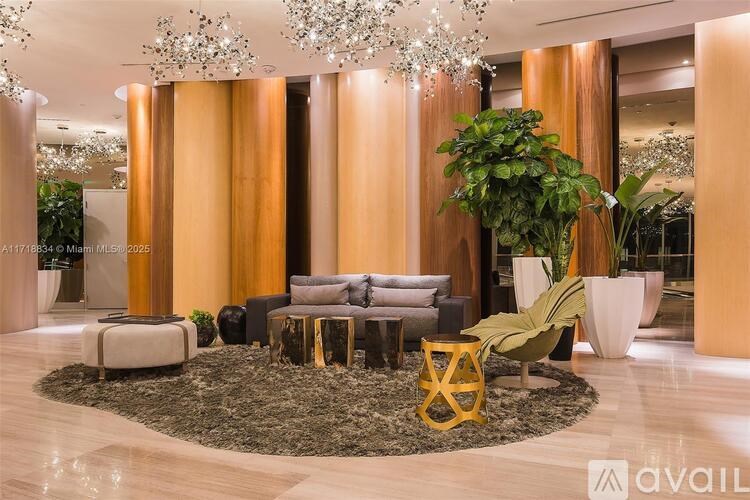 A modern living room with a large grey sofa, a yellow chair, and a chandelier.